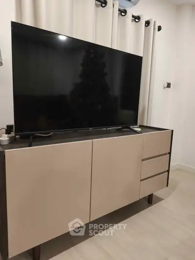 Modern living room with sleek TV stand and large flat-screen TV
