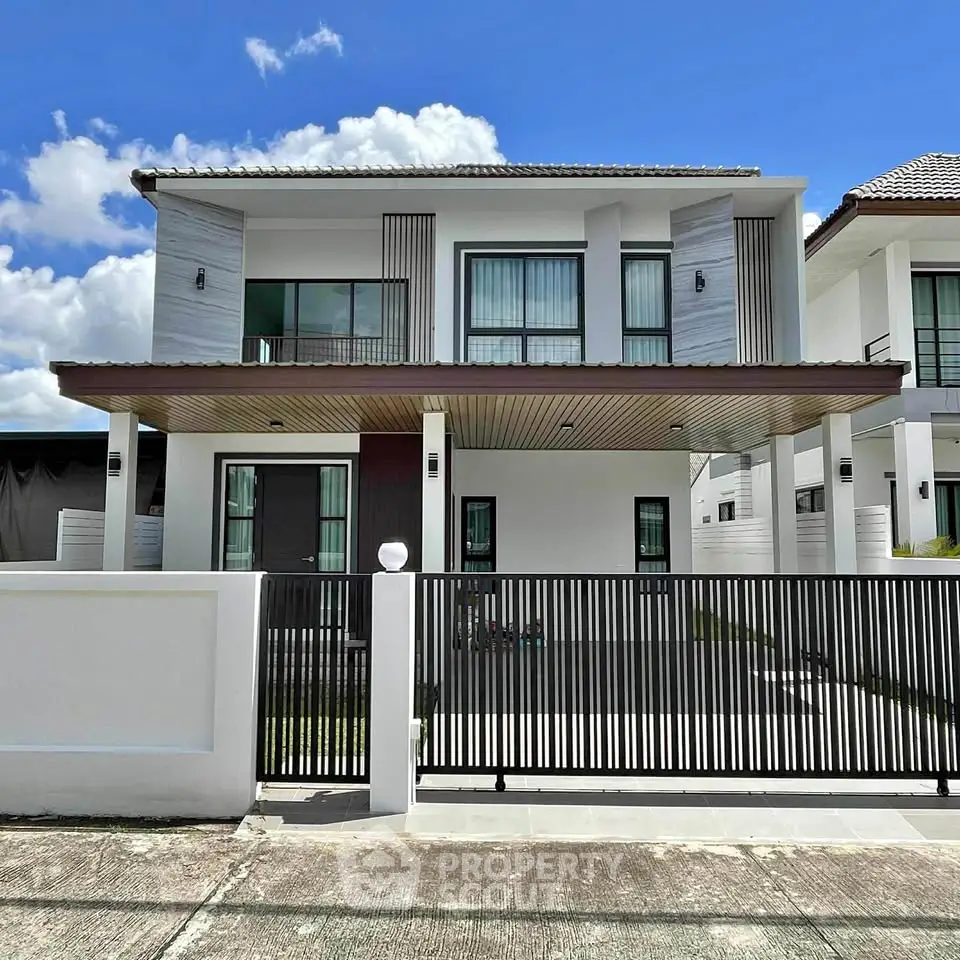 Modern two-story house with sleek design and spacious driveway under a clear blue sky.
