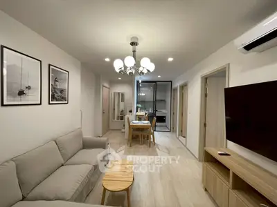 Modern living room with elegant decor and open layout leading to dining area and kitchen.
