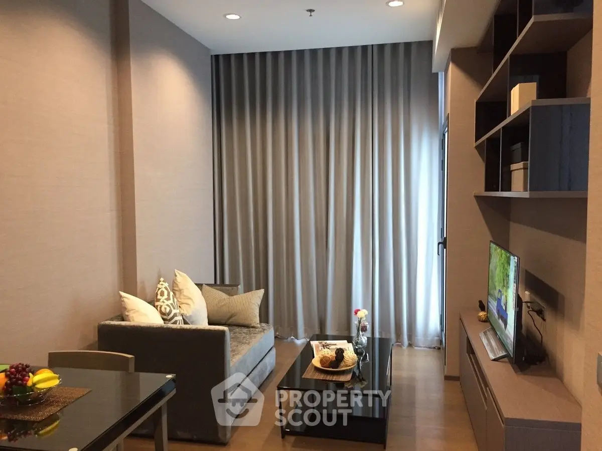 Modern living room with cozy sofa, stylish decor, and natural light from large window.