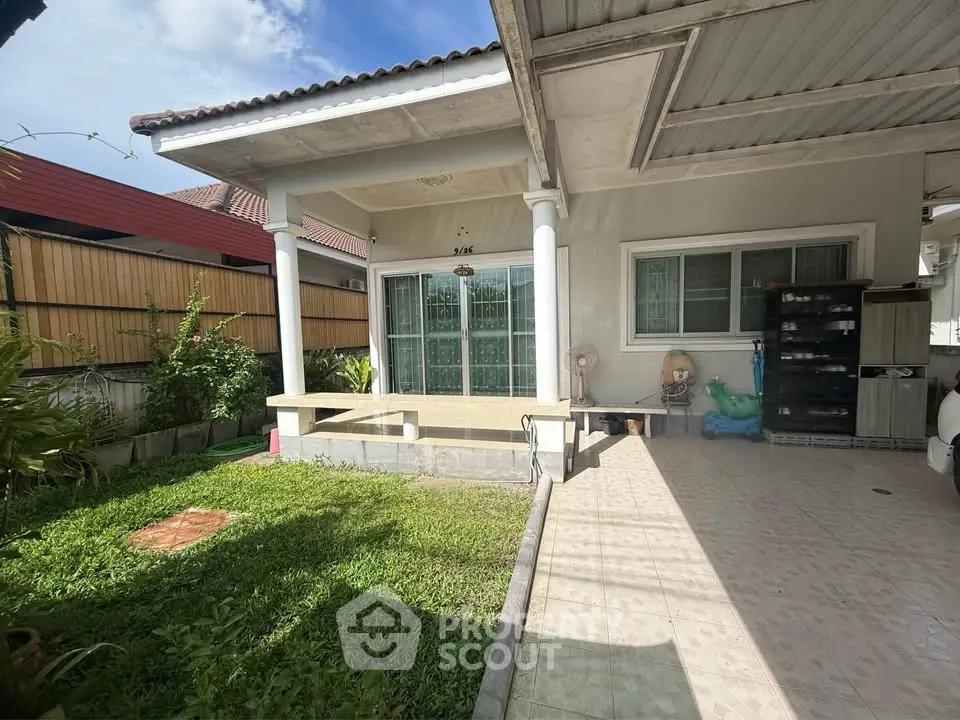 Charming single-story home with covered patio and lush garden, perfect for outdoor relaxation.