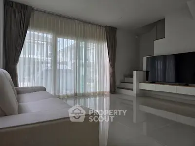 Modern living room with sleek design, large windows, and stylish furniture in a contemporary home.