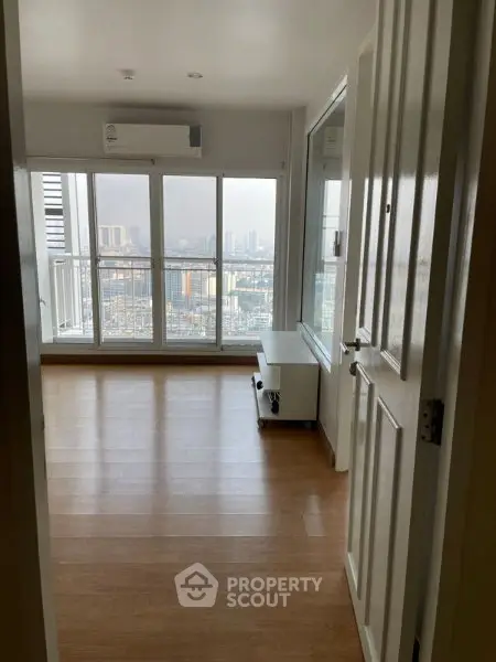 Spacious room with large windows offering stunning city views and natural light.