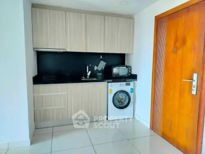 Compact kitchen with modern appliances and wooden cabinetry