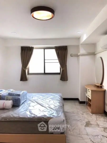 Spacious bedroom with natural light and modern furnishings