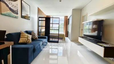 Modern living room with sleek design, featuring a blue sofa, large TV, and natural light from floor-to-ceiling windows.