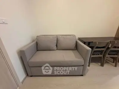 Cozy corner with a modern gray sofa and dining table, perfect for compact living spaces.
