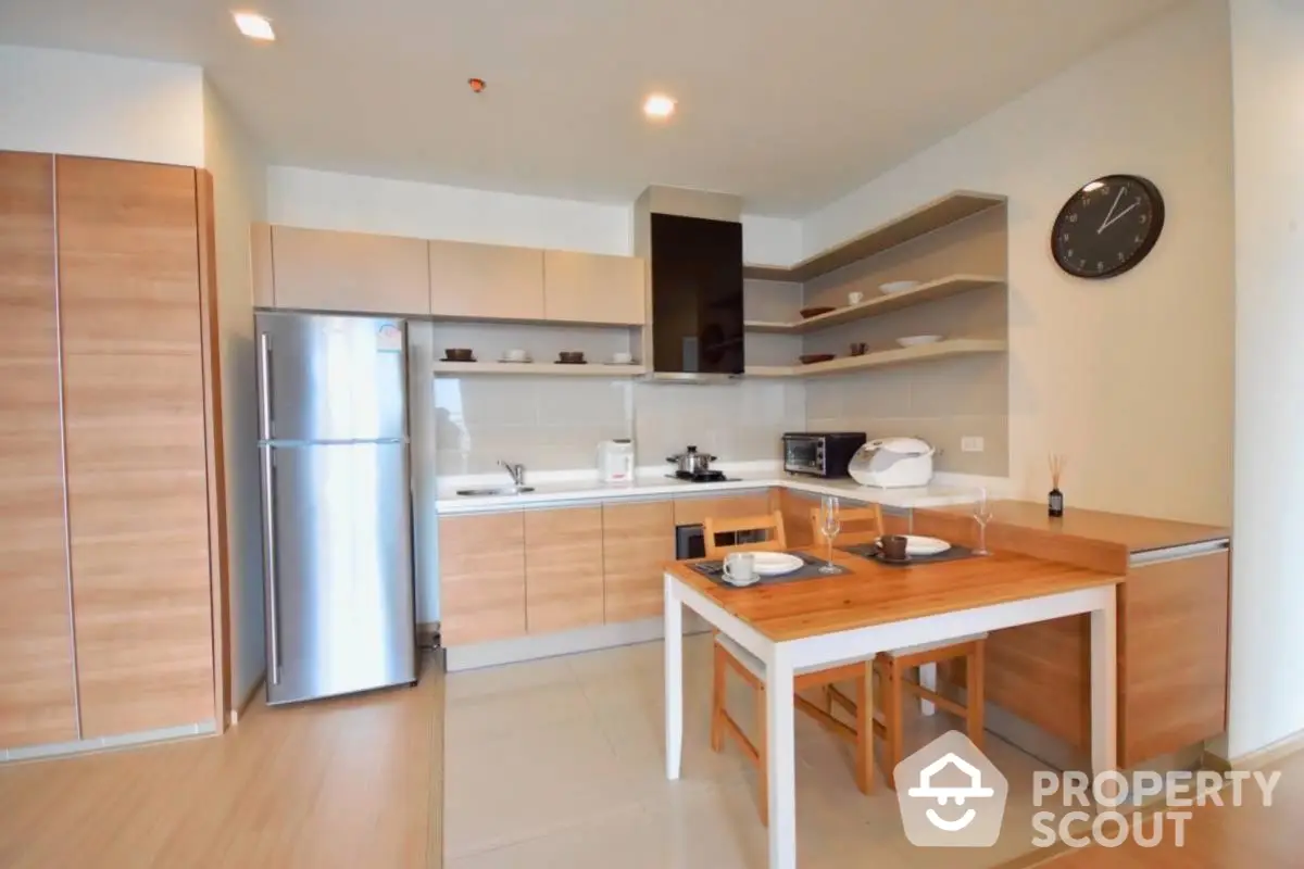 Modern kitchen with wooden cabinets and dining area in open layout apartment