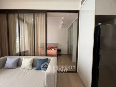Modern apartment interior with cozy living room and bedroom view, featuring stylish decor and natural light.