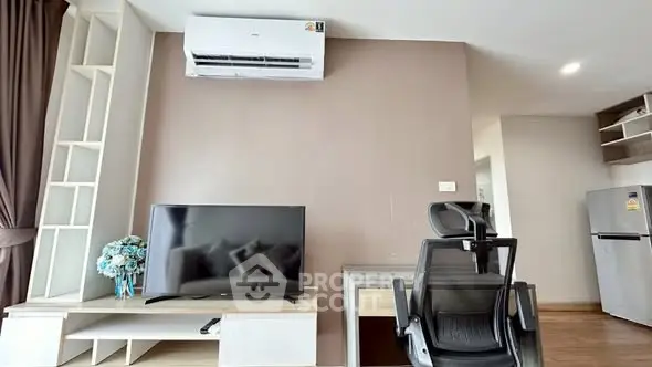 Modern living room with TV, desk, and air conditioning in a stylish apartment.