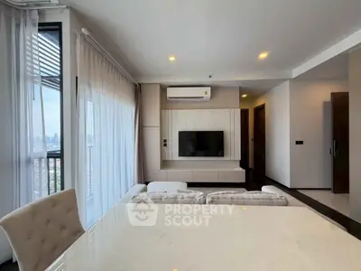 Modern living room with city view, featuring sleek furniture and a mounted TV.