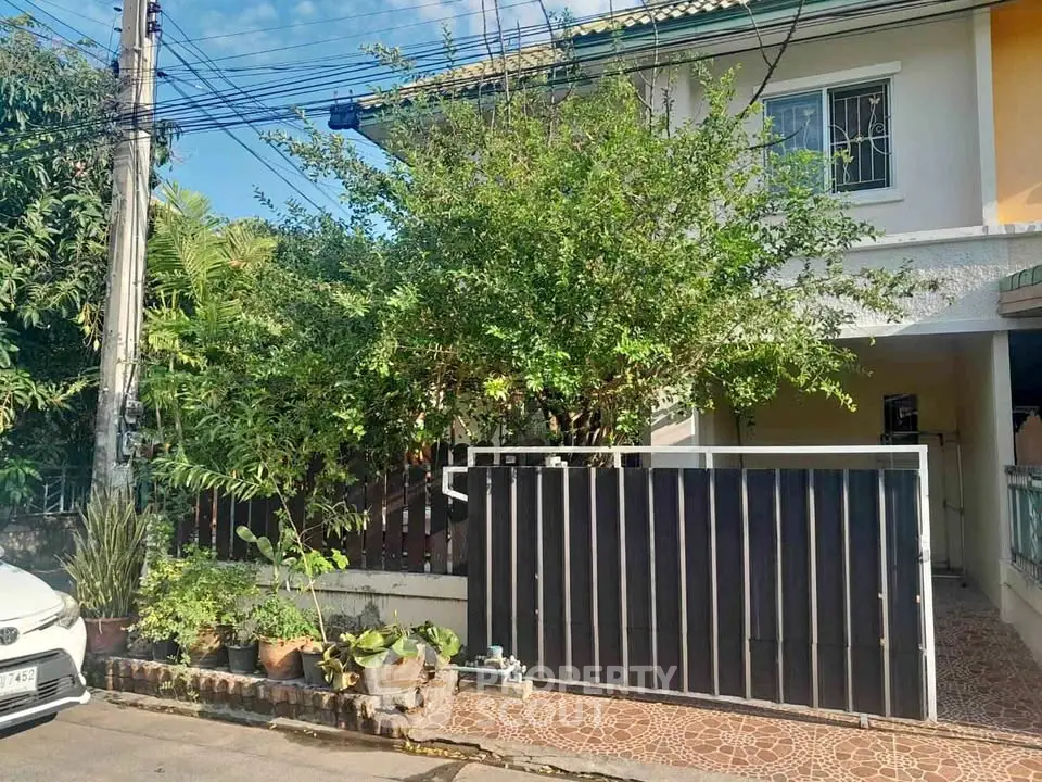 Charming suburban home with lush greenery and secure gated entrance.