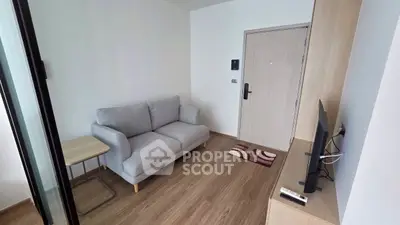Cozy living room with modern sofa and TV, perfect for relaxation.