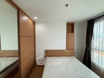 Modern bedroom with wooden accents and large window offering natural light