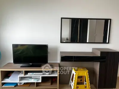 Modern living room with TV stand, mirror, and contemporary furniture setup.