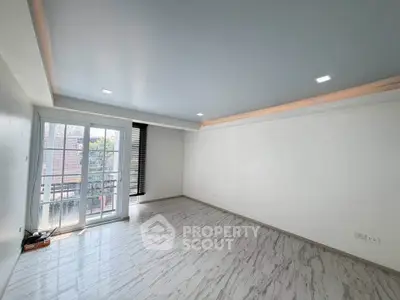 Spacious empty living room with large windows and modern ceiling lights