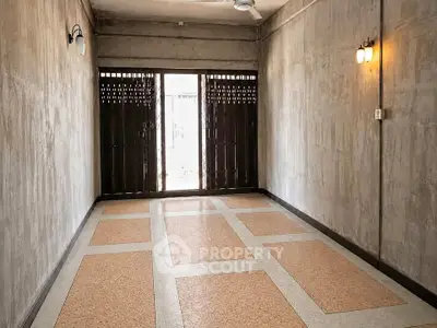 Spacious empty room with unique flooring and rustic walls, perfect for customization.