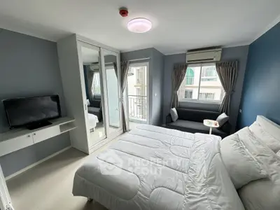 Modern bedroom with mirrored wardrobe and cozy seating area