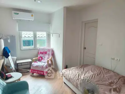 Cozy bedroom with modern decor, featuring a comfortable bed, air conditioning, and natural light from the window.