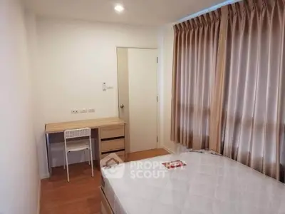 Cozy bedroom with natural light, featuring a study desk and comfortable bed, ideal for restful living.