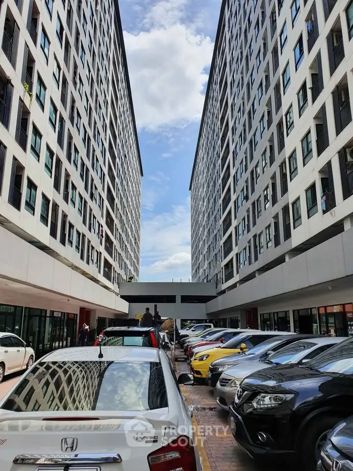Modern apartment complex with ample parking and sleek architectural design.