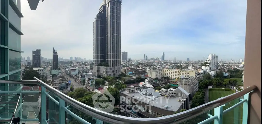 Stunning cityscape view from a high-rise balcony with modern glass railing.