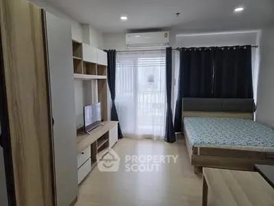 Modern studio apartment with wooden furnishings and natural light