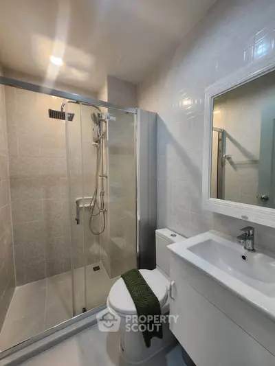 Modern bathroom with glass shower enclosure and sleek white fixtures