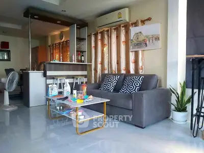 Modern living room with stylish sofa and open kitchen layout, perfect for cozy gatherings.