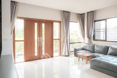 Spacious living room with large windows and modern leather sofa