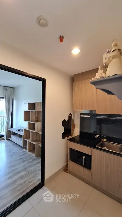 Modern kitchen with wooden cabinets and open layout leading to stylish living room
