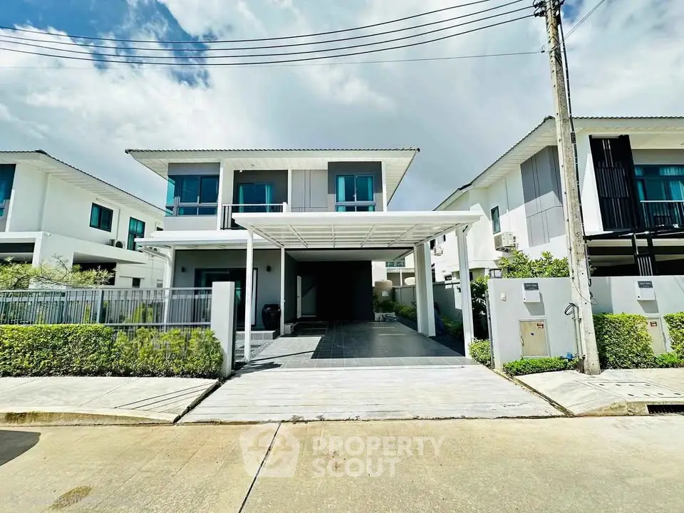 Modern two-story house with carport and landscaped front yard in a suburban neighborhood.