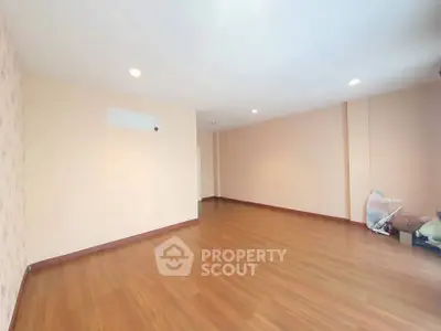 Spacious empty room with wooden flooring and soft lighting, ideal for customization.
