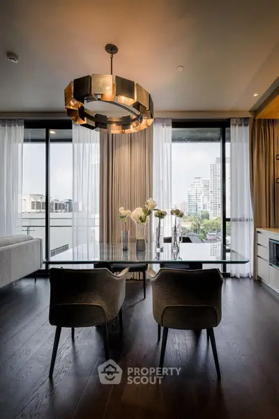 Luxurious modern living room with elegant dining area and city view, featuring stylish chandelier and floor-to-ceiling windows.