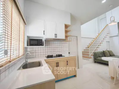 Modern kitchen with gas stove and open layout leading to stylish living area