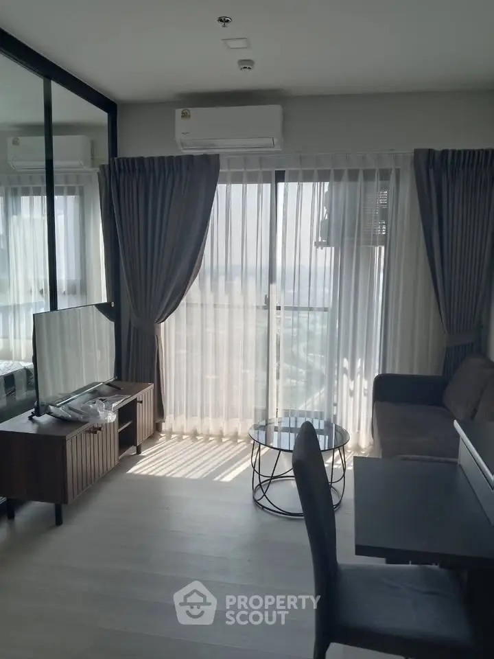 Modern living room with large windows and stylish furniture in a high-rise apartment