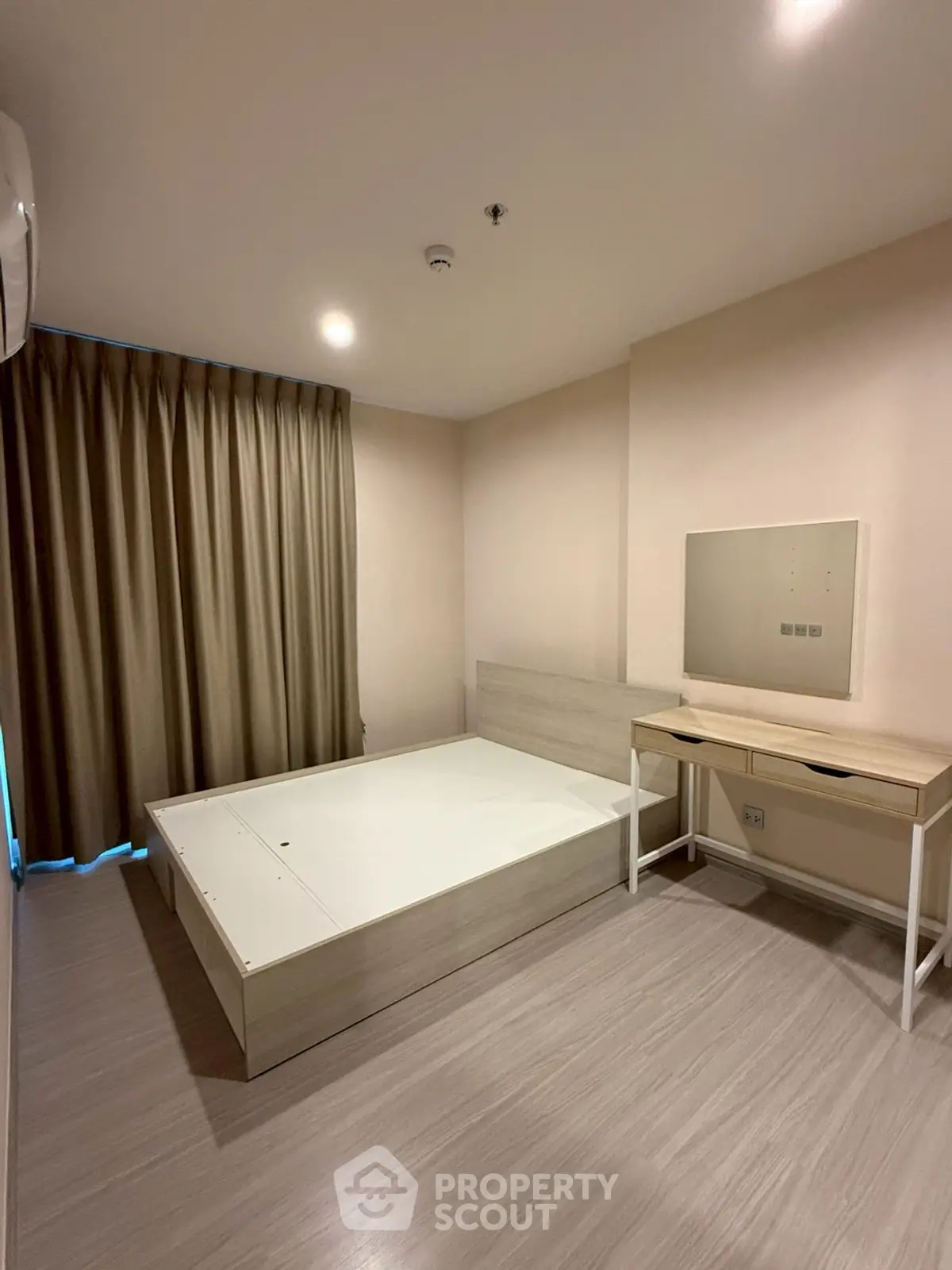 Spacious bedroom with modern minimalist design and ample natural light.