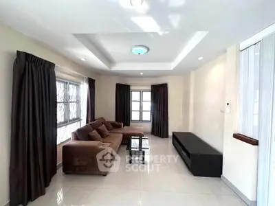 Spacious living room with modern sofa and natural light, perfect for relaxation and entertainment.