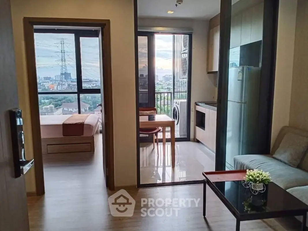 Modern apartment with open kitchen and stunning city view from balcony.