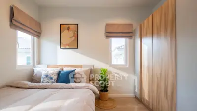 Cozy bedroom with natural light, modern decor, and ample storage space.