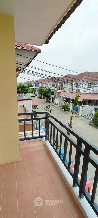 Charming balcony view in suburban neighborhood with tiled flooring and railing.