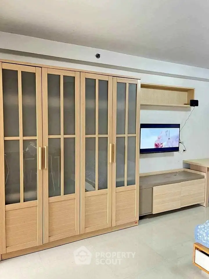 Spacious living room with modern wooden cabinetry and wall-mounted TV