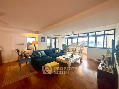 Spacious living room with city view, modern decor, and ample natural light.
