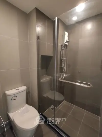 Modern bathroom with glass shower enclosure and sleek tile design.