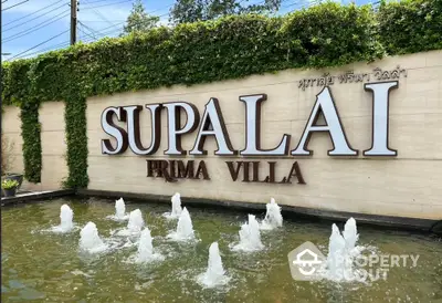 Elegant entrance of Supalai Prima Villa with water fountain and lush greenery.