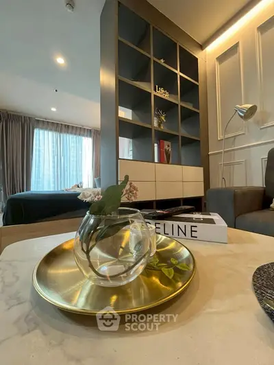 Modern living room with stylish decor and open layout, featuring a cozy seating area and elegant shelving.