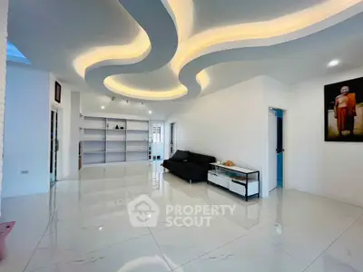 Spacious modern living room with unique ceiling design and sleek flooring