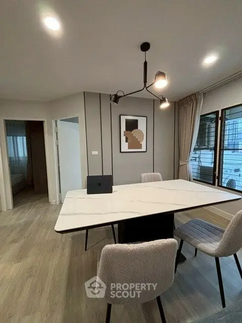 Modern dining area with sleek table and stylish chairs in a contemporary apartment.