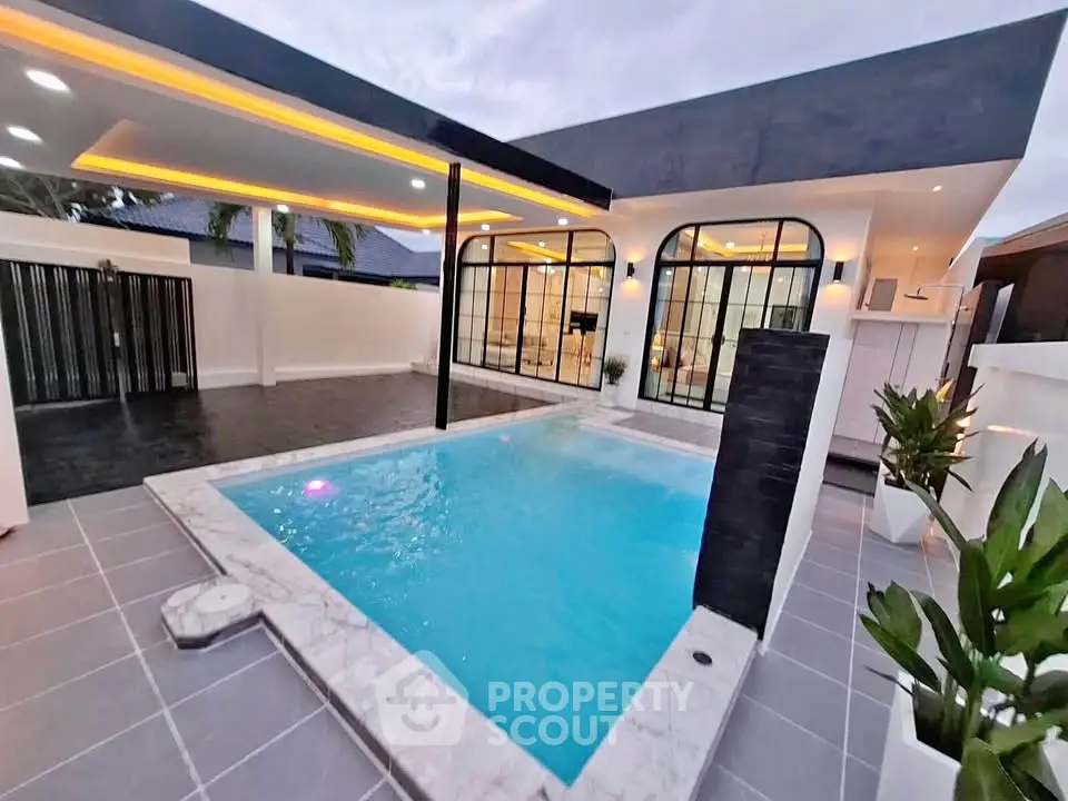 Luxurious modern home with sleek pool and stylish outdoor lighting.