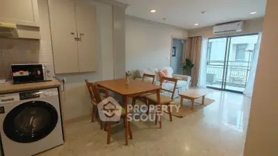 Charming living room with dining area and balcony access in modern apartment.